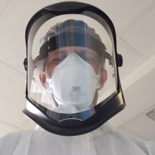 Dr Skittrall wearing PPE whilst assessing patients for infectious diseases in his clinical practice