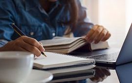 Student handwriting information on diary notebook while reading book shutterstock_1700556118r.jpg