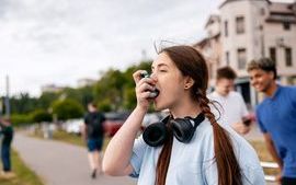 Young woman administering medicine with an inhaler